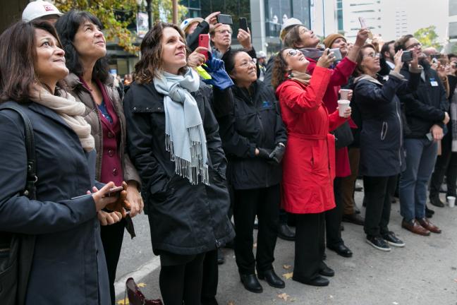 Elected leaders, construction workers, judges, architects, and others members of the project team watch as final beam is being hoisted to the top of the Multnomah County Central Courthouse Project
