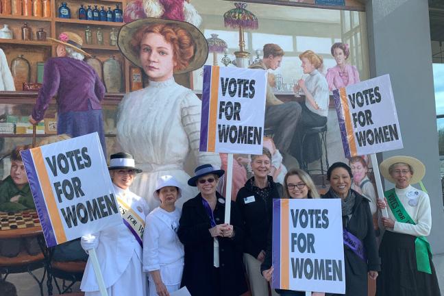 Commissioner Stegmann join women in costume in celebrating the right to vote.