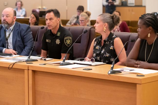 Sheriff Mike Reese gives presentation at 2019 board meeting. On his left is Abbey Stamp, executive director of the Local Public Safety Coordinating Council and Erika Preuitt, director of Department of Community Justice. 