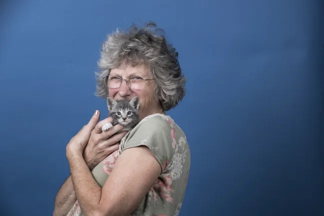 Woman snuggling a kitten 