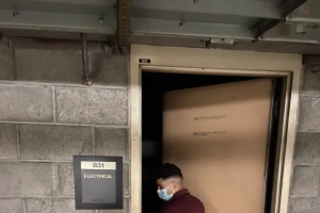 Young man in mask enters doorway