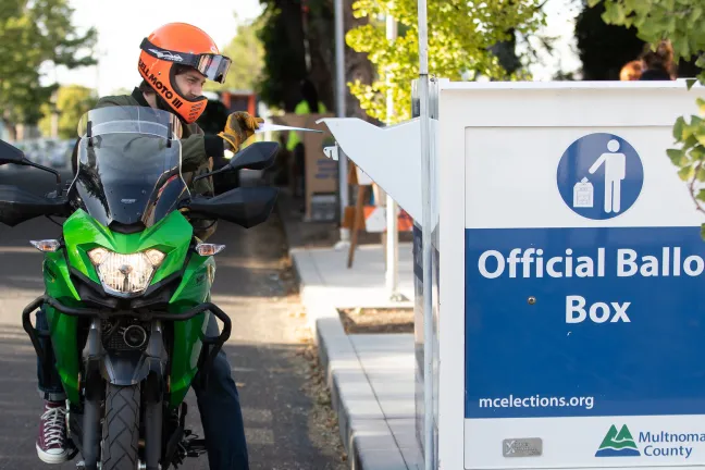 motorcyclist dropping ballot at drop site
