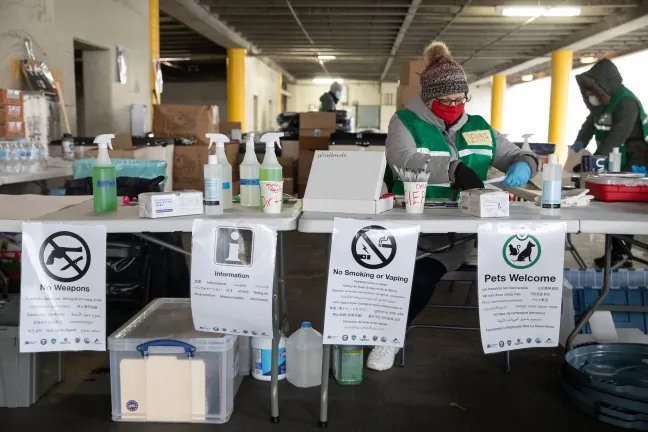 Indvidual prepares to greet guests to a severe weather shelter site.
