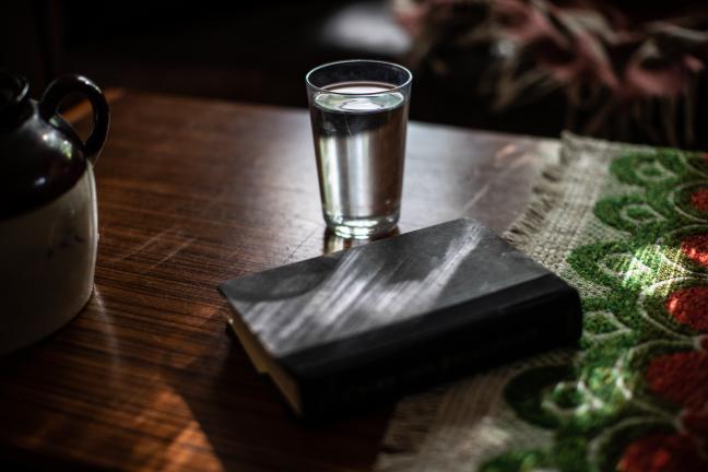 Water glass in a room with shades drawn to avoid heat.