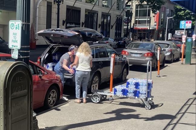 Loading up water for a volunteer on Friday, June 25, 2021, outside the JOHS supply center.