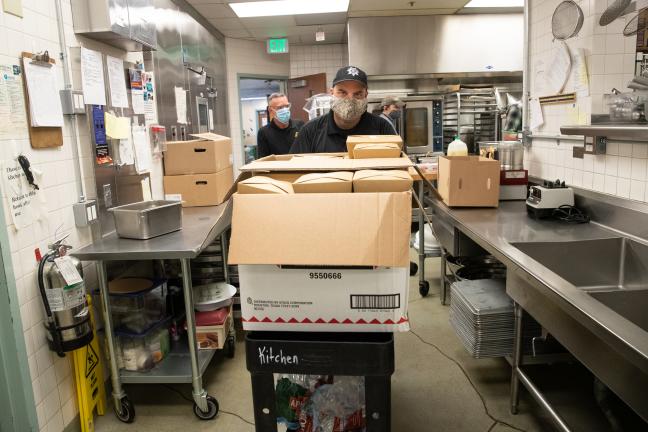 Mental Health Unit officers John McVay and Joe Wenhold pick up meals prepared by the County’s Juvenile Services Division’s Courtyard Café and Catering Service. 