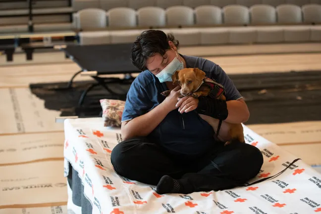 Guest hugs dog at Kellogg Middle School cooling center.