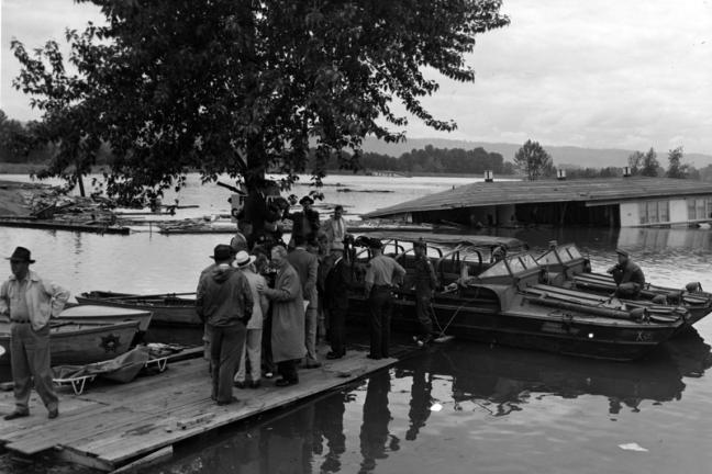 President Harry S. Truman is in Oregon inspecting flood damage. He is with a group of men who are not identified. President Truman is on his Western Trip.