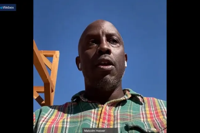 Malcolm Hoover (centro) dirigiéndose a la Junta filmado en su teléfono celular