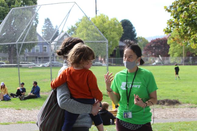 Suzanne Chou, community engagement coordinator with the bond team, speaks with a library user at a recent in-person event to gather feedback on the community’s vision for Albina and North Portland libraries. 