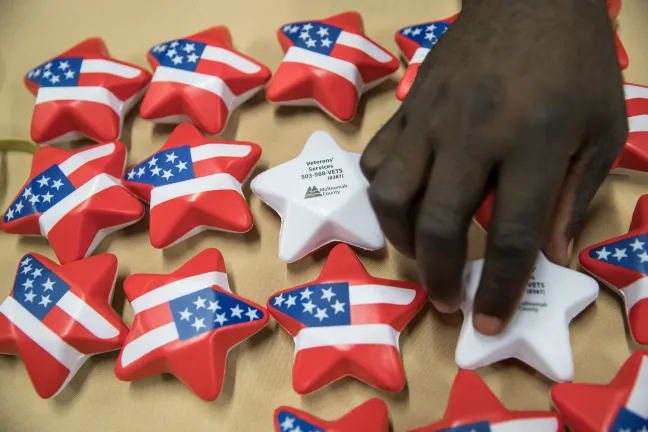 Un oficial de servicio para veteranos endereza una mesa informativa.