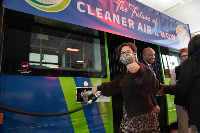 Commissioner Vega Pederson puts a thumb up in approval of a renewable diesel bus