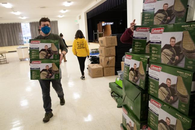 Portland's Houseless Strategies Manager Jake Dornblaser hauls sleeping bags for the winter shelter at the Mt. Scott Community Center, Dec. 24, 2021