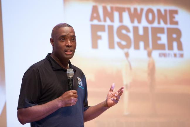 Antwone Fisher stands on stage to share his story with POIC + Rosemary Anderson High School and Multnomah County staff.