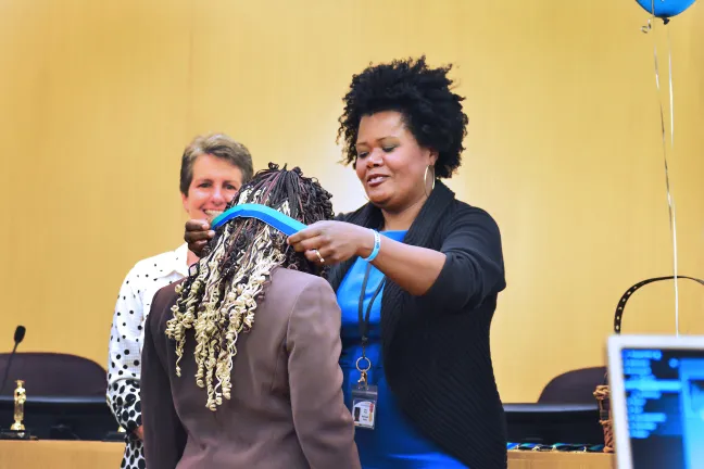 Student ambassadors were honored at the graduation as well. Five students were given a medal for their dedication to bringing resources and support to their peers. Here, DCJ District Manager Erika Preuitt awards Namkisiah Roper her medal. 