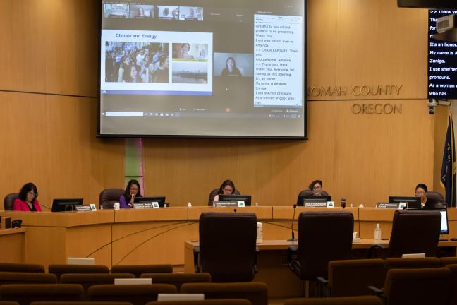 The Board sitting in front of a projector displaying a sustainability presentation