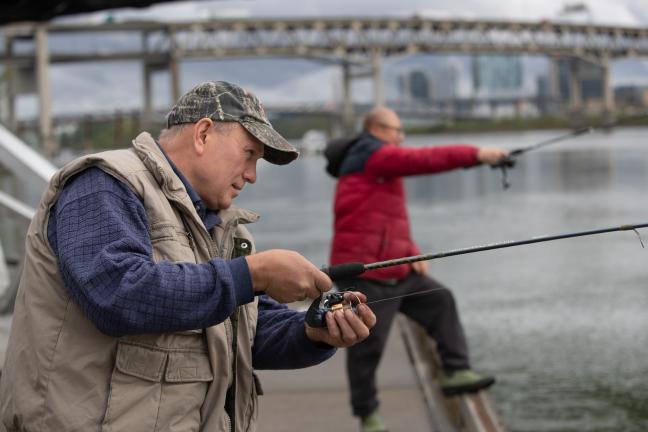 Local fishers Yevgeniy Ruban (left) and Dan Yan (right) fishing in the Lower Willamette River.