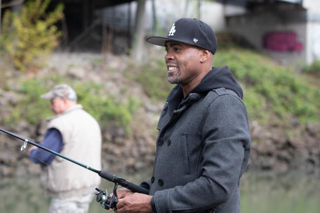 Dishaun Berry (center), a local fisherman, is fishing in the Lower Willamette River.