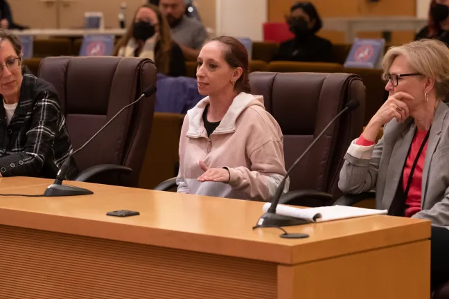 Jen Godwin, center, tells commissioners about how Wraparound services helped her son and her family find stability.