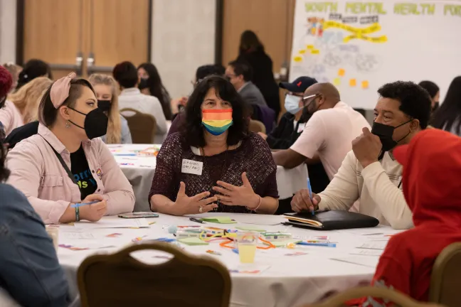 Commissioner Sharon Meieran, center, joined a table of young people to talk about youth mental health