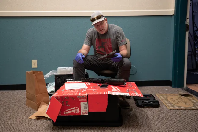 Sgt. Matt Ferguson, who leads the Sheriff’s Office’s Special Investigations Unit, processes weapons seized in Operation Safer Multnomah