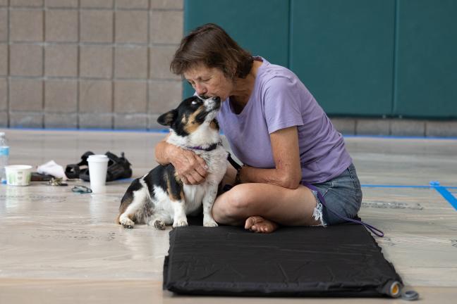 Person snuggling her pet at cooling center