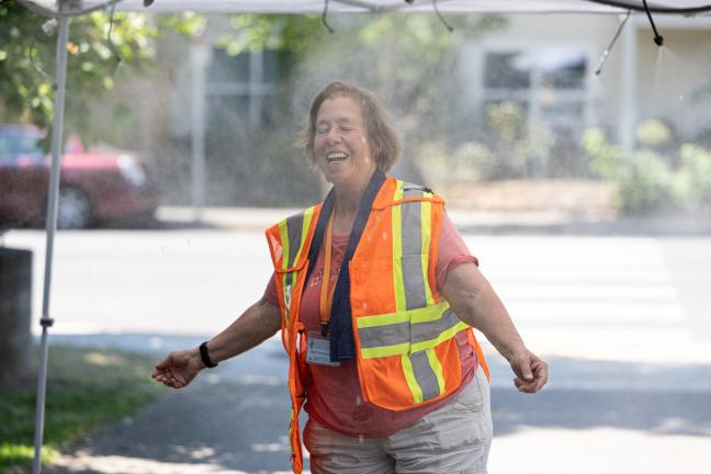 A volunteer cools off after setting up a misting station, July 26, 2022