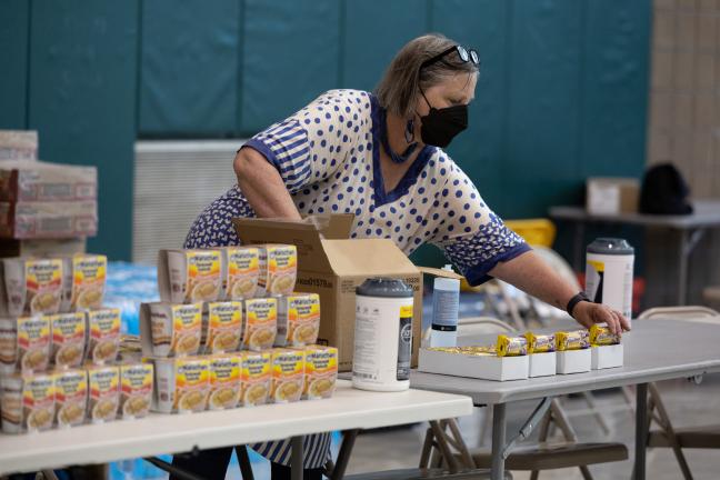 Beth Appert, a Public Health employee, lays out snacks at a cooling shelter, July 26, 2022