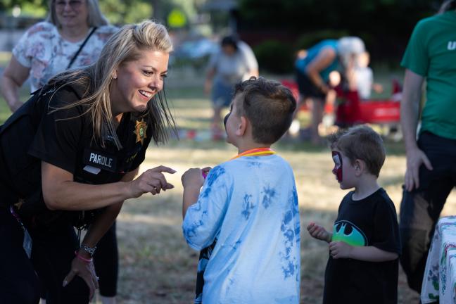 Jamie Tynan, Multnomah County Department of Community Justice parole and probation officer smile at her son at National Night Out event at Kirk Park. 