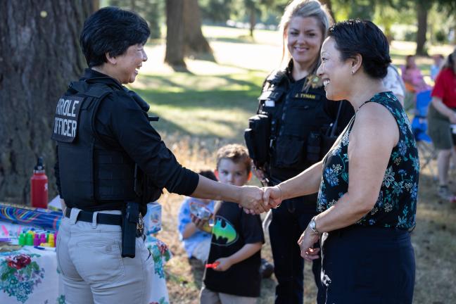 Commissioner Lori Stegmann shakes hands with Multnomah County Department of Community Justice parole and probation officer Thanh Dang.