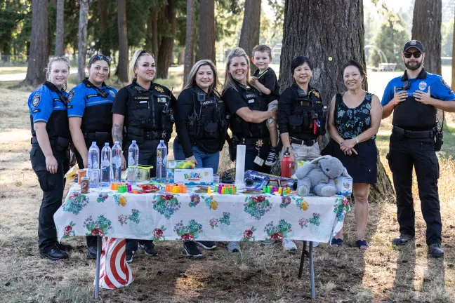 From left: Two Gresham Police cadets pose with Multnomah County parole and probation officers Amie Kellogg; Laura Vejar; Jamie Tynan and her son; Thanh Dang; Commissioner Lori Stegmann and a Gresham Police cadet.