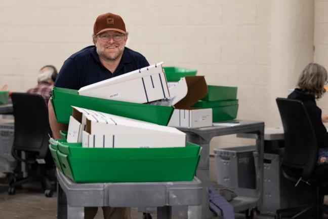 Election workers help with the processing ballots and preparing opening boards.