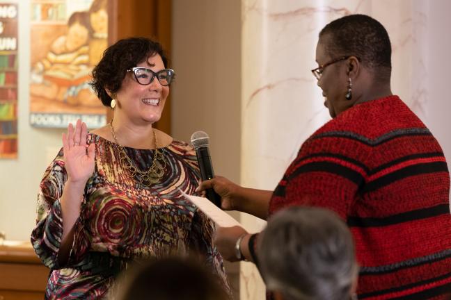 Chair Jessica Vega Pederson raises her right hand as she stand in front of and is sworn in by Oregon Supreme Court Justice Adrienne Nelson