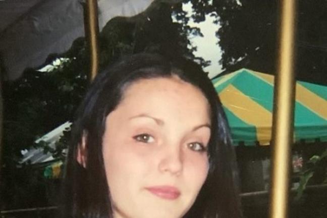 A photo of a woman with dark hair wearing a red shirt