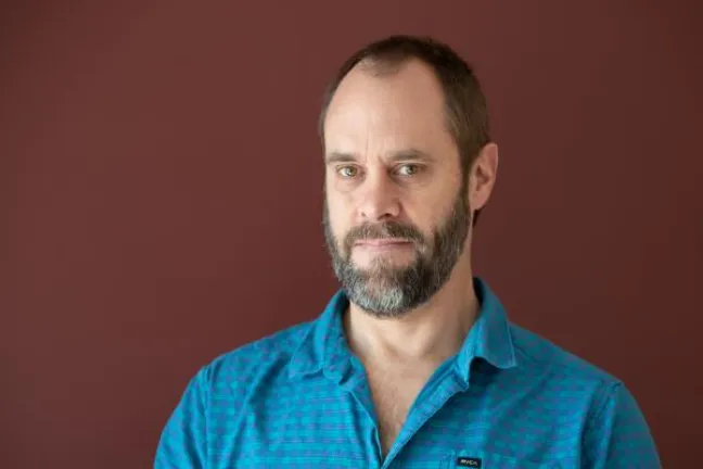 A photo of Perry Cabot, of the County's Lead Poisoning Prevention Program, with a red background