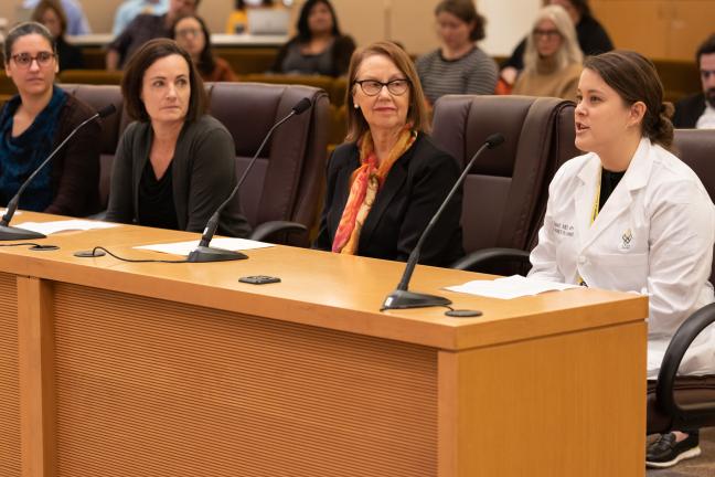 A photo of Dr. Julia Tasset speaking in a white lab coat