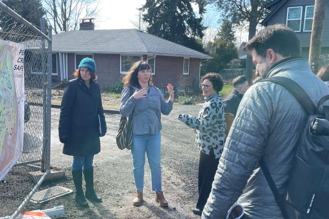 Several people stand outside a gate