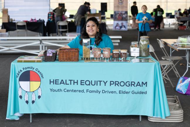 Lucy Suppah sits at a booth at the FGC event