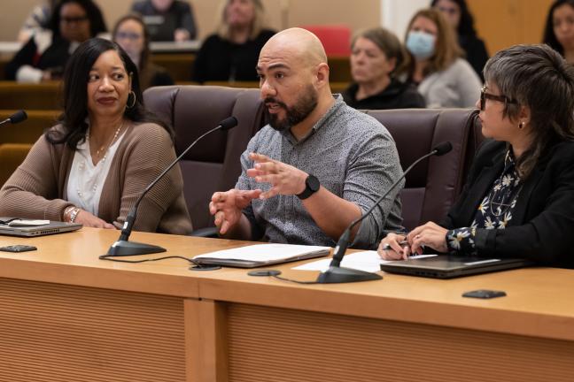 Office of Diversity and Equity Workforce Equity Manager Alejandro Juárez, center, speaks to the Board. He was joined by Chief Diversity and Equity Officer Joy Fowler (left) and Workforce Equity Senior Policy Analyst April Rohman (right).