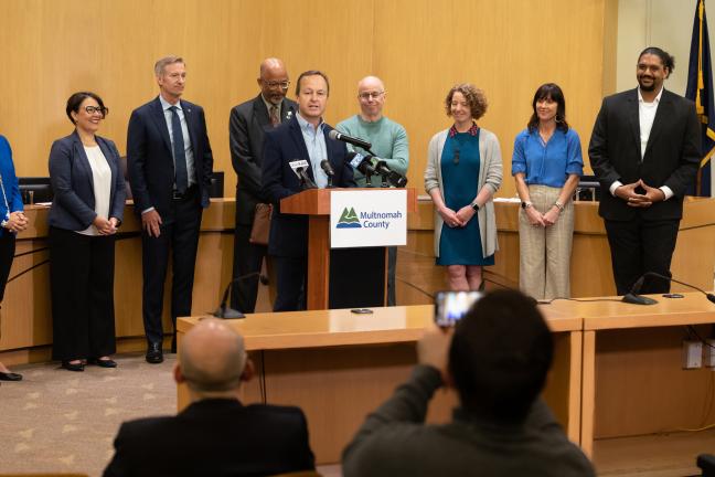 Photo of Dan Field speaking at podium in Multnomah County Boardroom