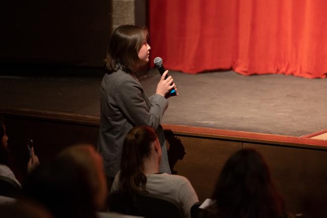 Byronie McMahon stands in audience with microphone