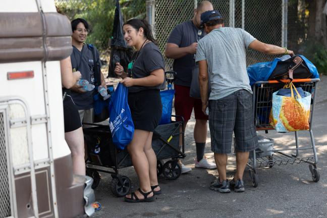 Outreach workers with Cultivate Initiatives, a Joint Office contractor, deliver County supplies to people without shelter in east Portland during the heat emergency Tuesday, Aug. 15, 2023.