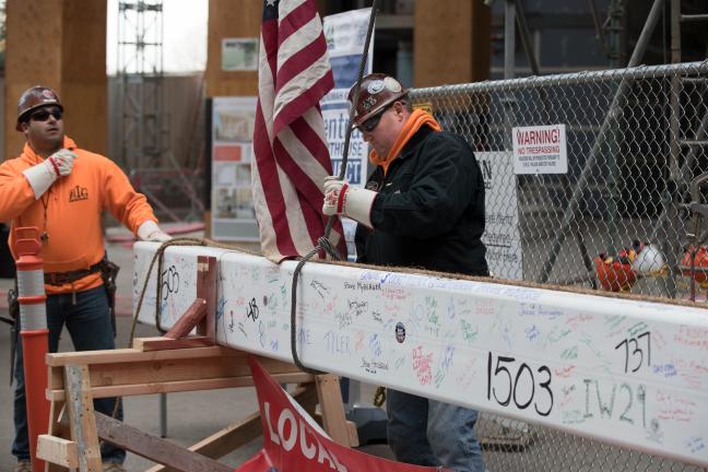 Worker prepares beam for lift to it's final resting place