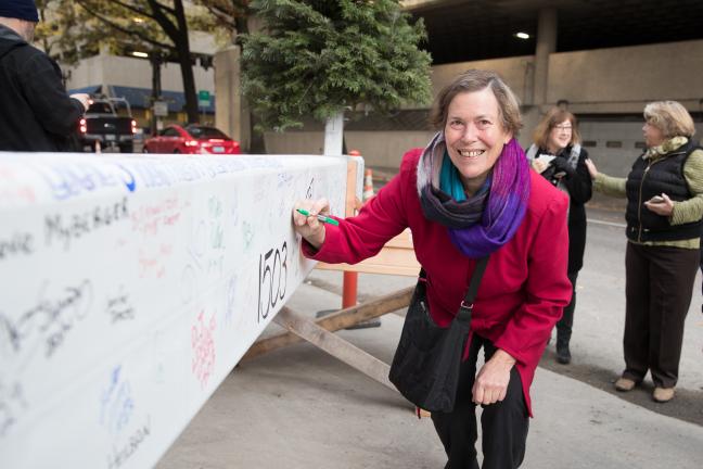 Former Commissioner and early supporter of courthouse project Judy Shiprack signs the courthouse beam.