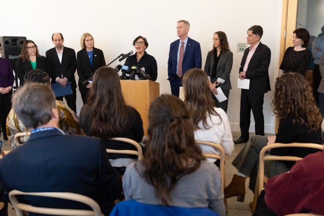 Chair Jessica Vega Pederson stands at dais alongside other elected officials and community leaders, including Mayor Ted Wheeler, Lori Stegmann, Julia Brim-Edwards and Mayor Ted Wheeler