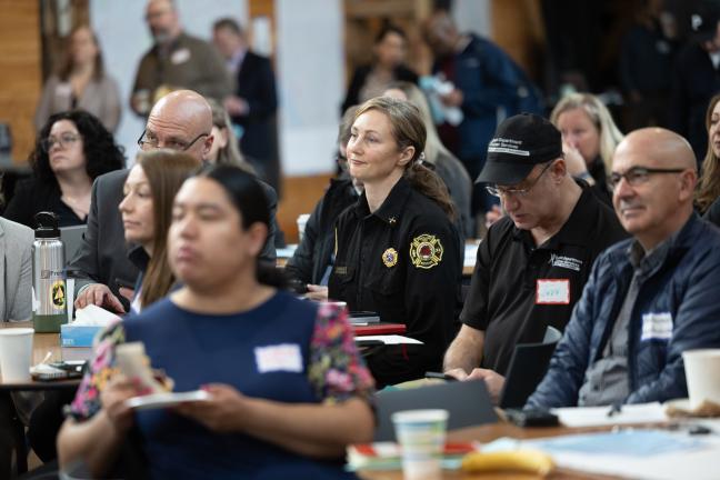 A photo of people sitting at a roundtable listening to a speaker at a fentanyl summit