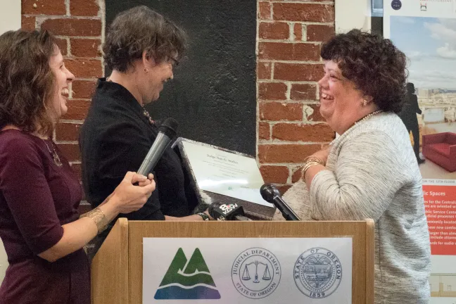 Commissioner Judy Shiprack and Chair Deborah Kafoury present a ceremonial masonry brick to Judge Nan Waller