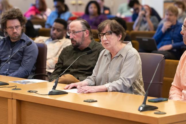 Three people sit at the dais in the Multnomah County boardroom.