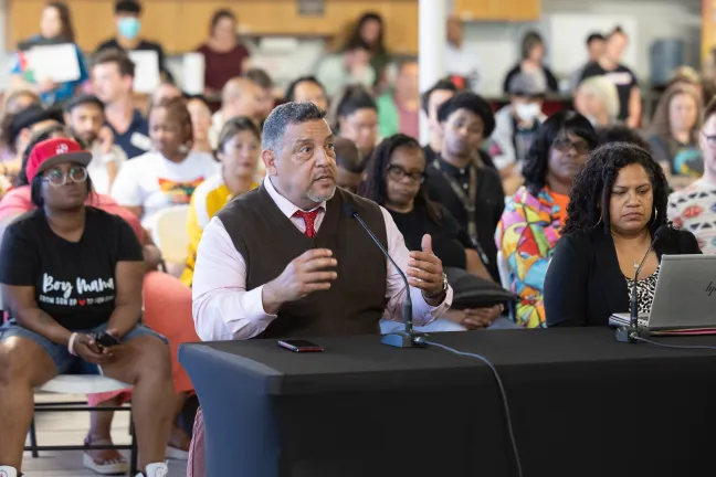 Rigler Elementary School Principal Chris Silvas pictured sitting at the table speaking to Board of Commissioners.