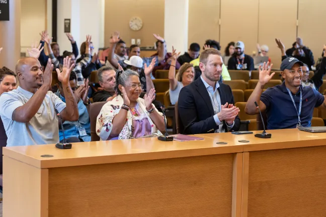 Community members with lived experience (from left) Shane Dorn, Lore Vences and Adam Auler, and the Office of Consumer Engagement supervisor Deandre Kenyanjui tell the Board their stories of their road to recovery.